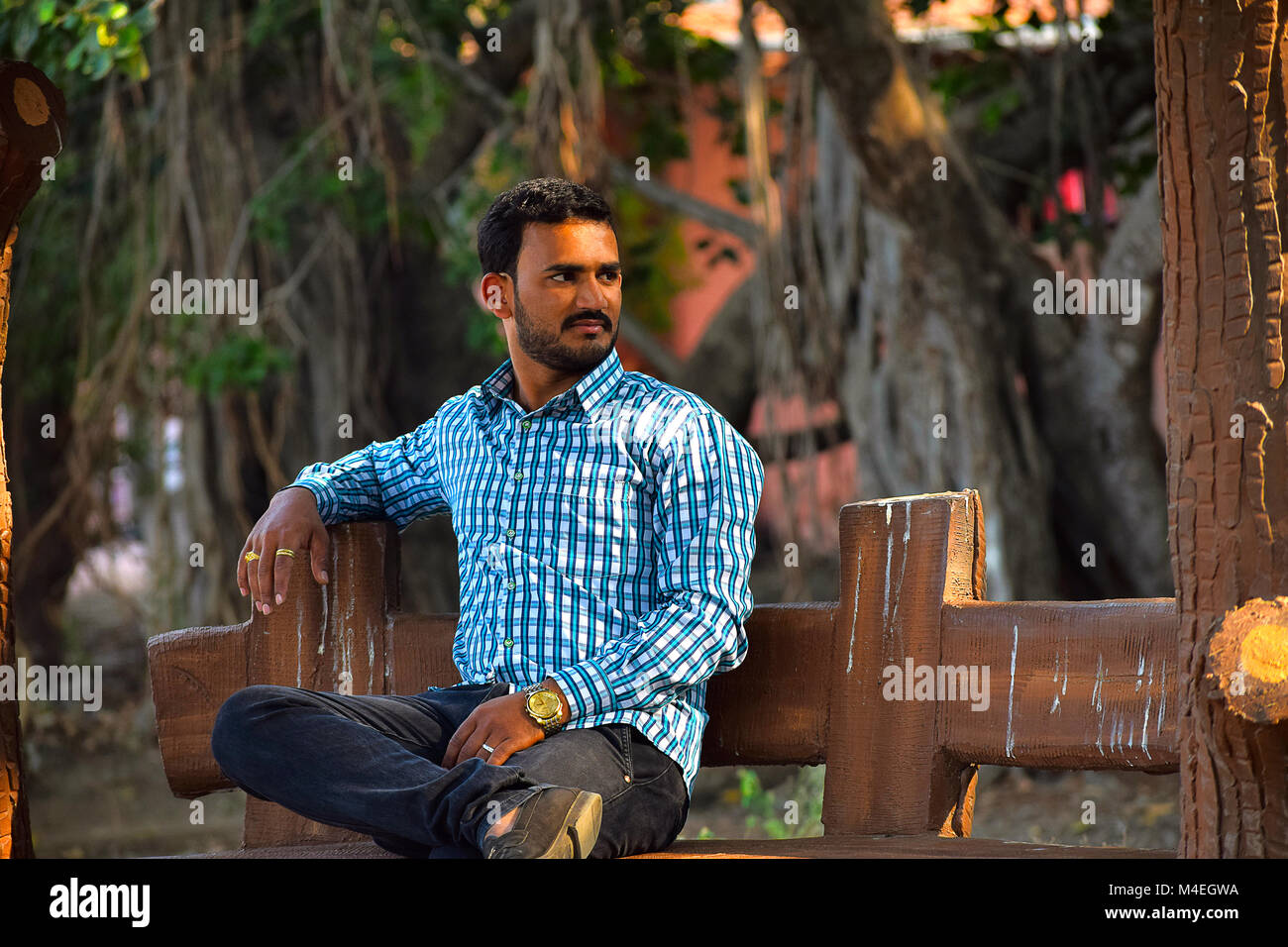 Homme assis sur un banc dans un jardin, Pune, Maharashtra. Banque D'Images