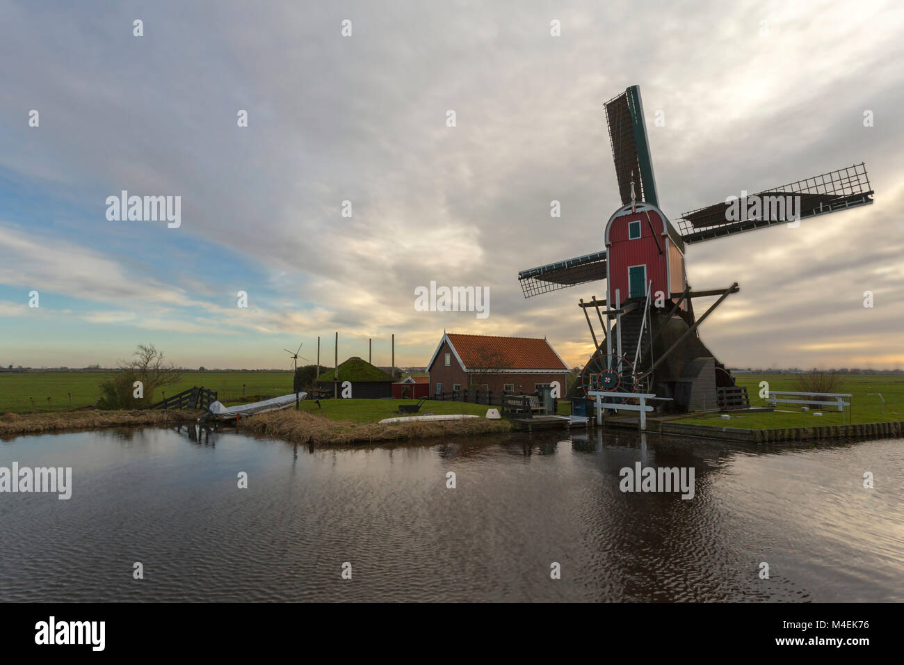 Un moulin à vent historique rouge, appelé Femme Vennemolen, situé dans un paysage de polders typiquement hollandais, Blauwe Polder, Oud Ade, Hollande méridionale, Pays-Bas. Banque D'Images