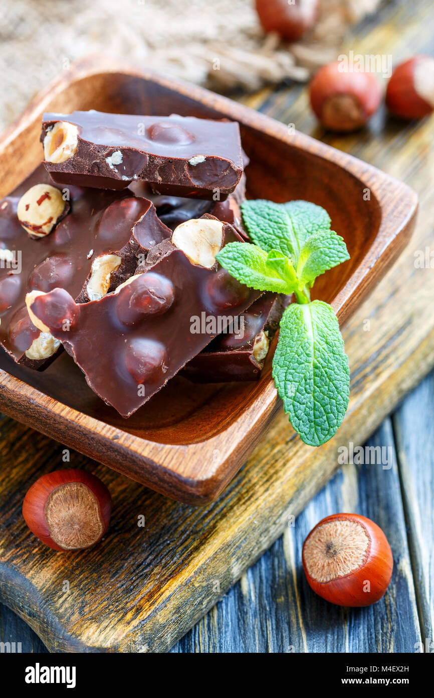 Bol en bois avec des morceaux de chocolat. Banque D'Images