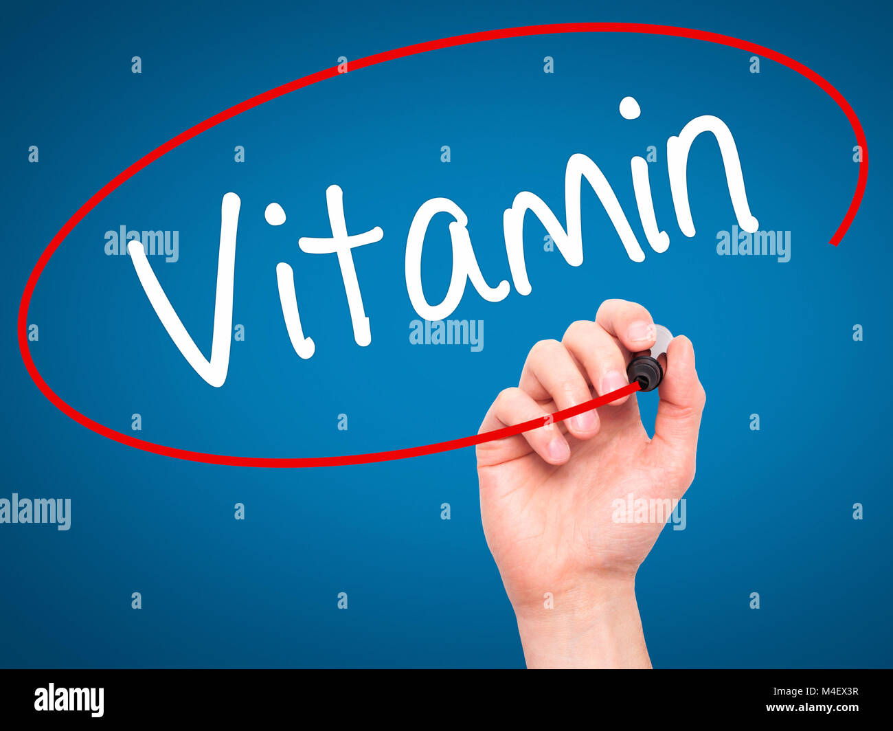 Man main écrit vitamine avec marqueur noir sur l'écran visuel Banque D'Images