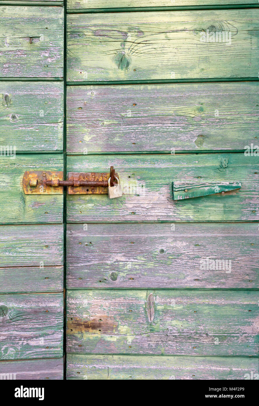 Vieille porte en bois vert avec de la peinture et de la poignée et serrure rouillée Banque D'Images