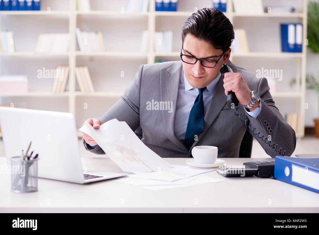 Businessman de renverser du café sur des documents importants Banque D'Images Businessman de renverser du café sur des documents importants Banque D'Images