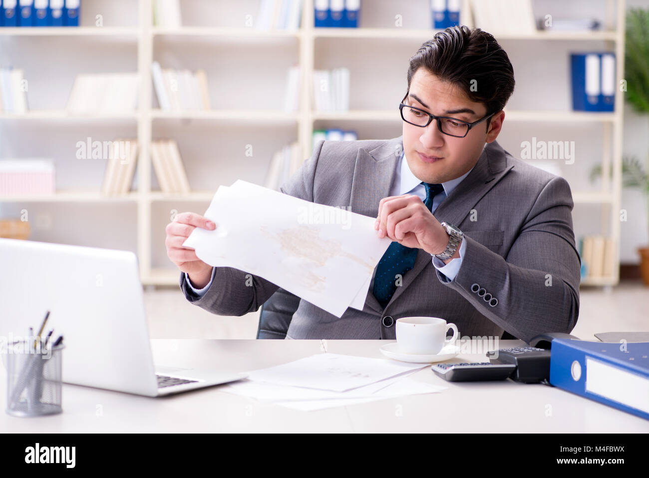 Businessman de renverser du café sur des documents importants Banque D'Images Businessman de renverser du café sur des documents importants Banque D'Images