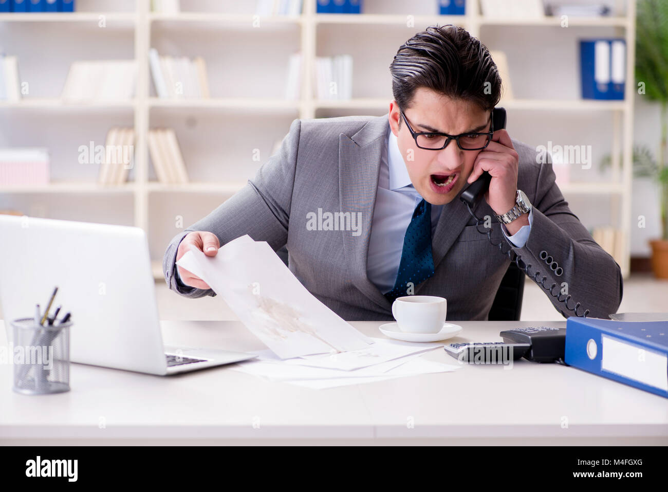 Businessman de renverser du café sur des documents importants Banque D'Images Businessman de renverser du café sur des documents importants Banque D'Images