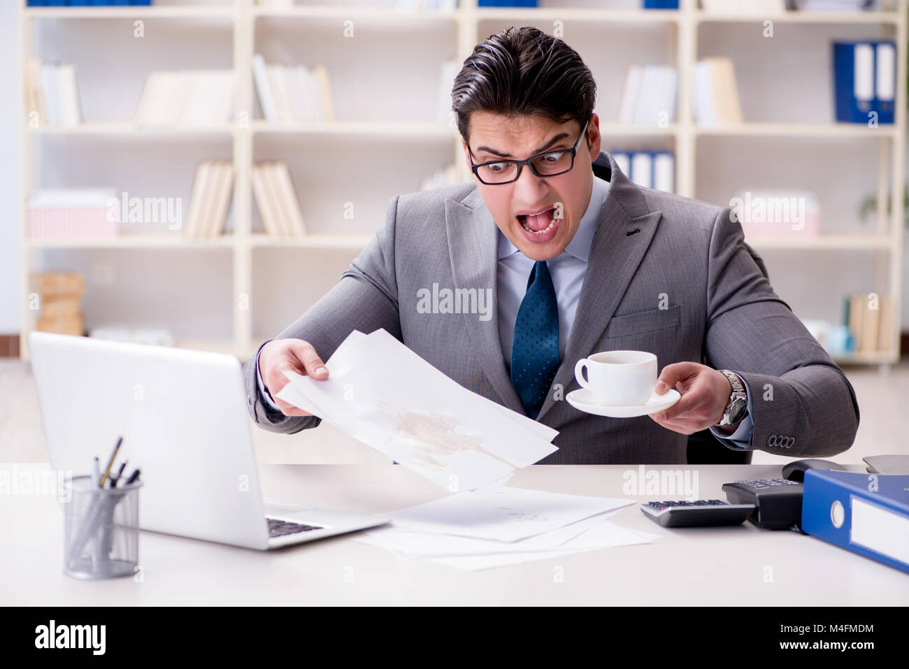 Businessman de renverser du café sur des documents importants Banque D'Images Businessman de renverser du café sur des documents importants Banque D'Images