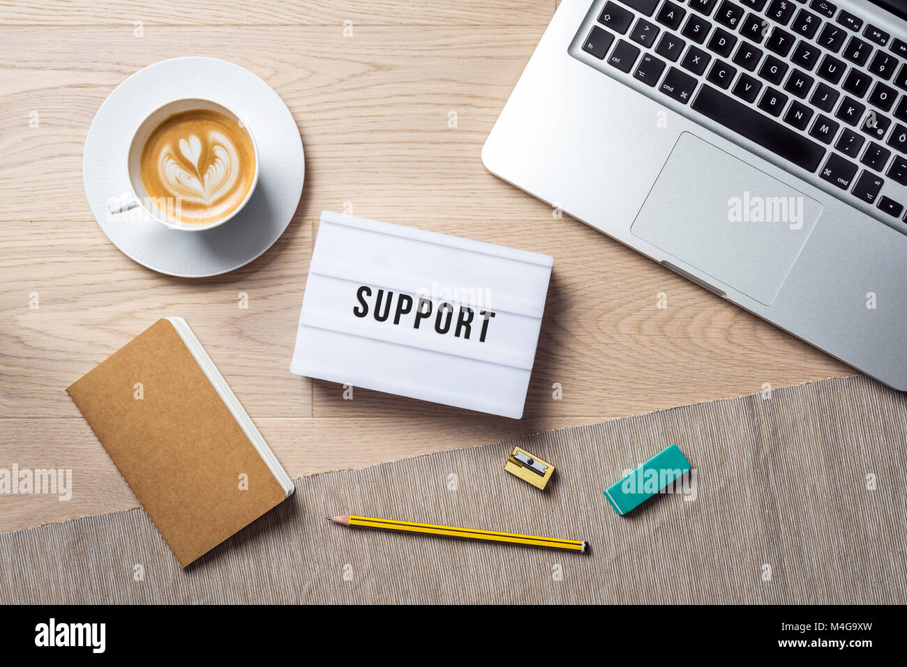 Dans l'écriture.jpg couché sur bureau en bois avec la tasse de café et de fourniture de bureau comme télévision pondre de bird's eye view Banque D'Images