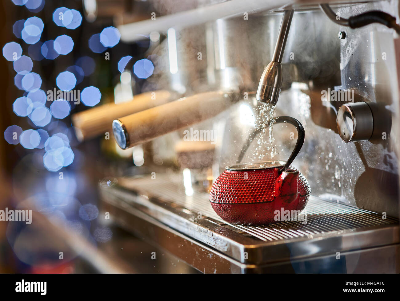 Faire un thé dans une tetsubin rouge avec une machine à café italienne classique. Banque D'Images