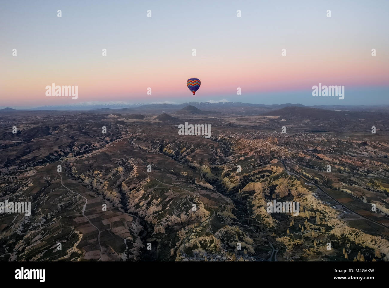 Vol en montgolfière sur la Cappadoce le matin au lever du soleil. Les montagnes peuvent être vu dans la distance avec badlands distinctes la topographie de la foregrou Banque D'Images