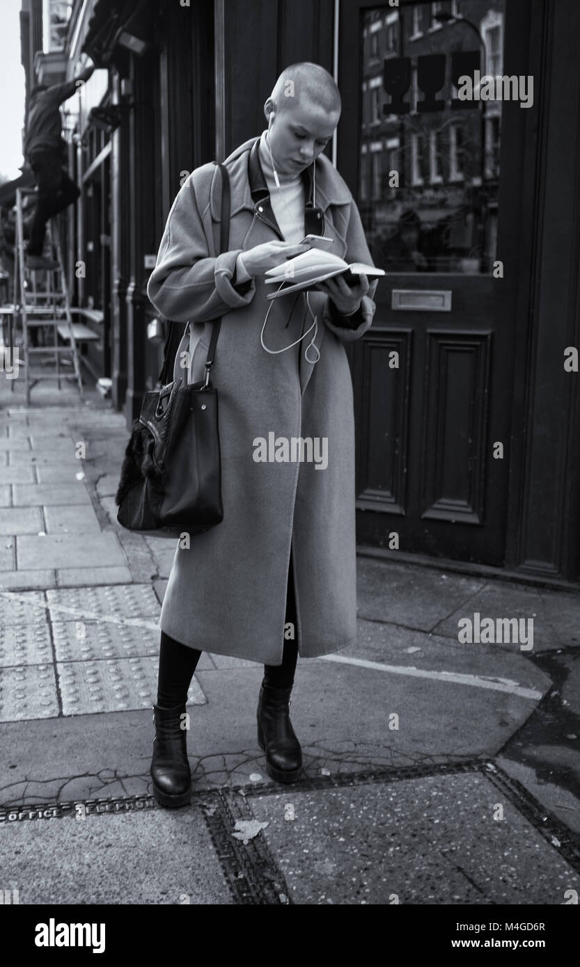 Photographie noir et blanc d'une femme le multi-tâche dans Fitzrovia, Londres, Angleterre, Royaume-Uni Londres Crédit : Snapper Banque D'Images