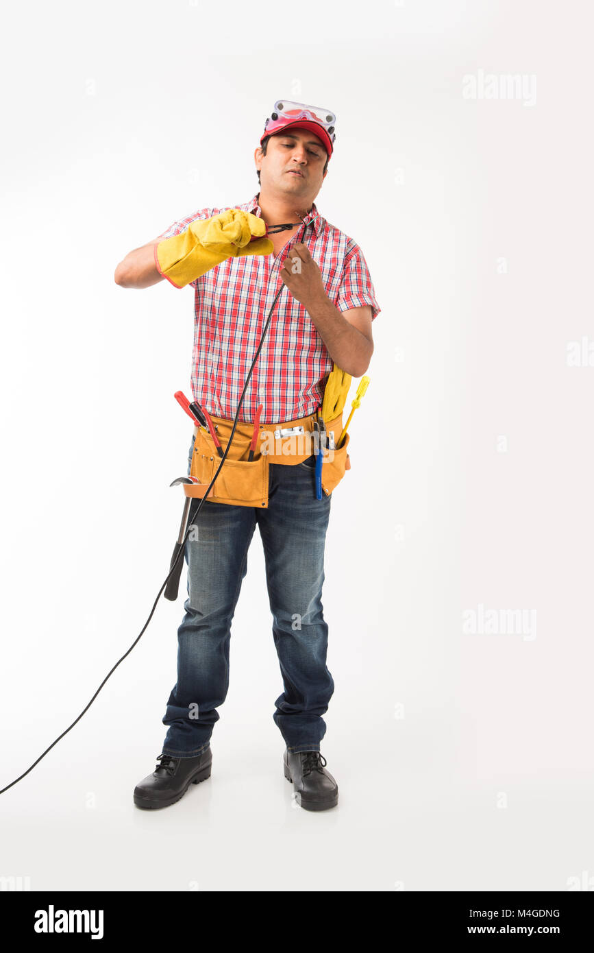 Ingénieur électricien indien en action avec coupe-fil machine de forage, etc, isolés sur fond blanc Banque D'Images