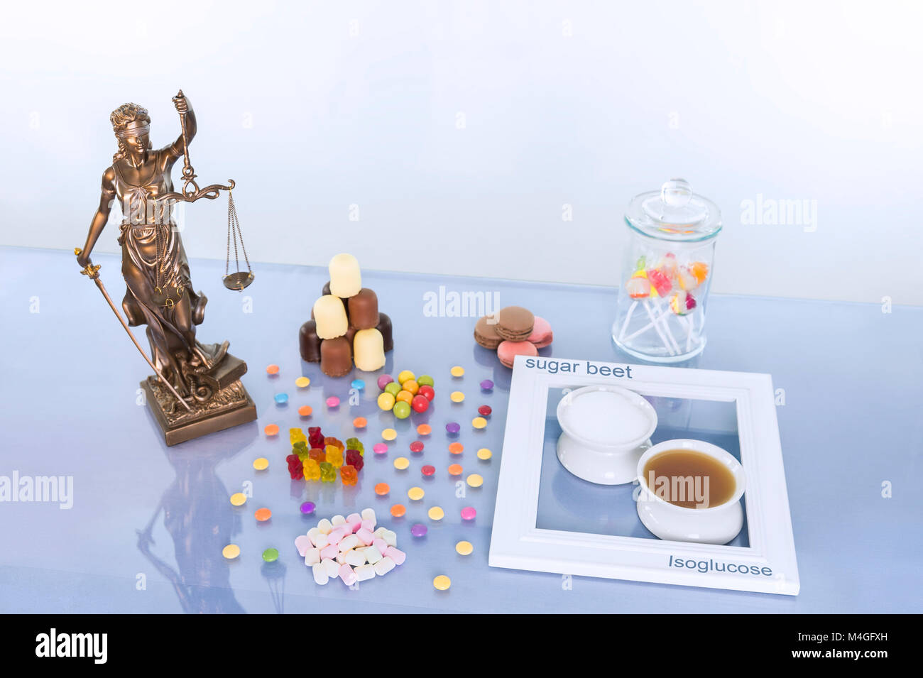 Justitia statue est sur la table avec beaucoup d'aliments sucrés. Pour comparaison, il y a chacune un bol de sucre et un bol de sucre industriel à côté de l'Othe Banque D'Images