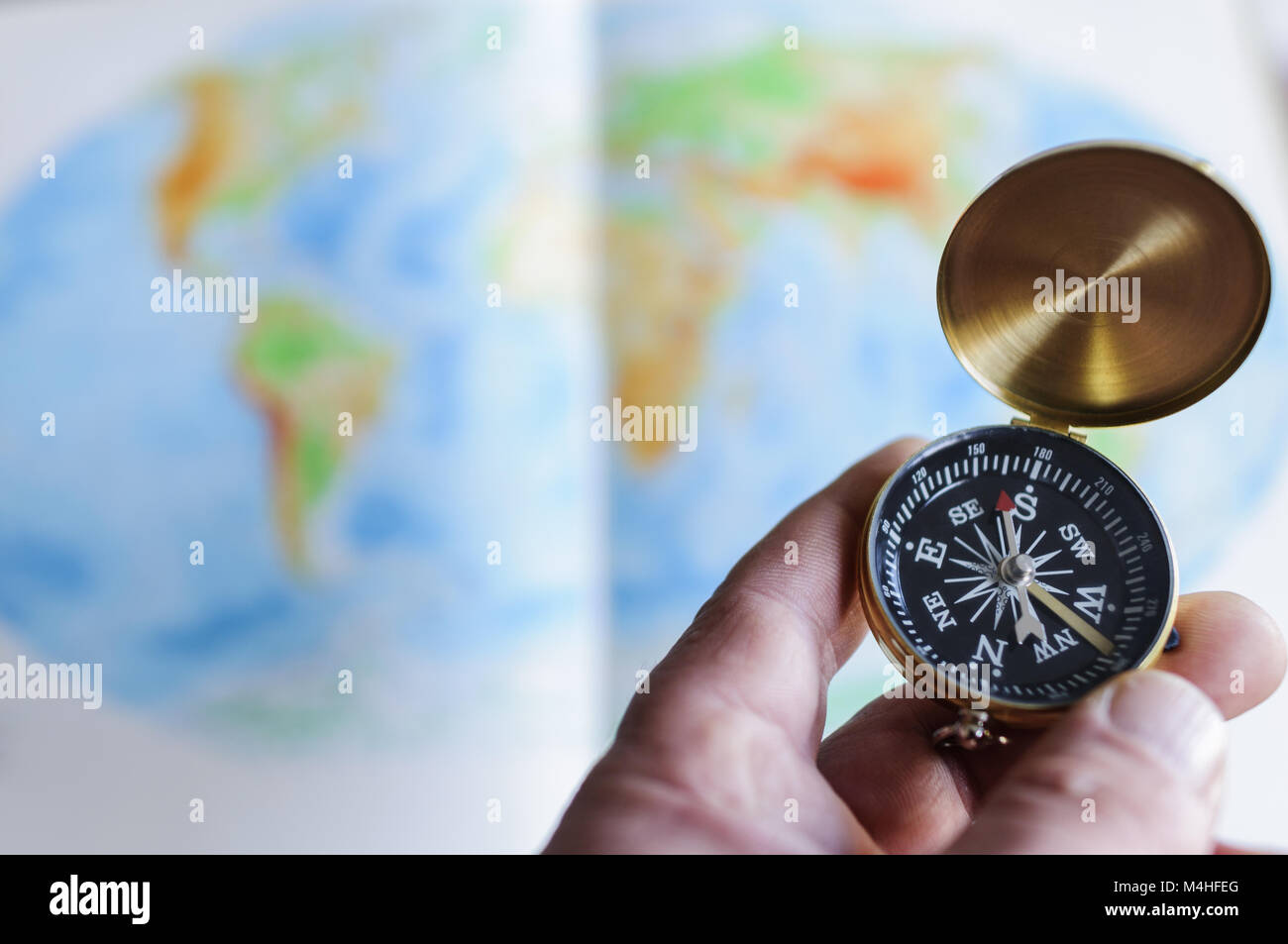 Hand holding compass en face de la carte du monde Banque D'Images