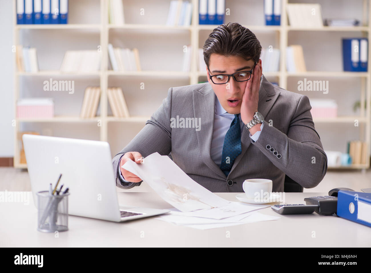 Businessman de renverser du café sur des documents importants Banque D'Images Businessman de renverser du café sur des documents importants Banque D'Images