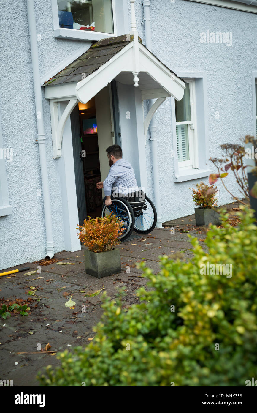 Homme handicapé ouvrant la porte Banque D'Images