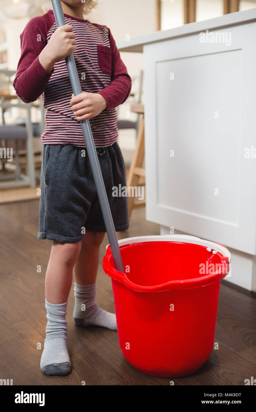 Boy holding marbre mop avec godet Banque D'Images