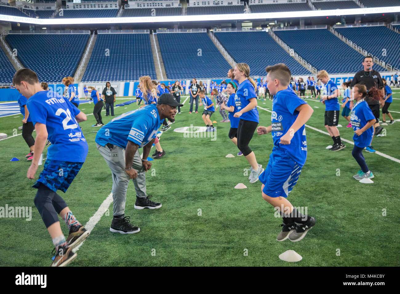 Detroit, Michigan - Detroit Lions linebacker Tahir Whitehead exécute les élèves à travers exercices de football lors d'une activité physique et de nutrition au sein Banque D'Images