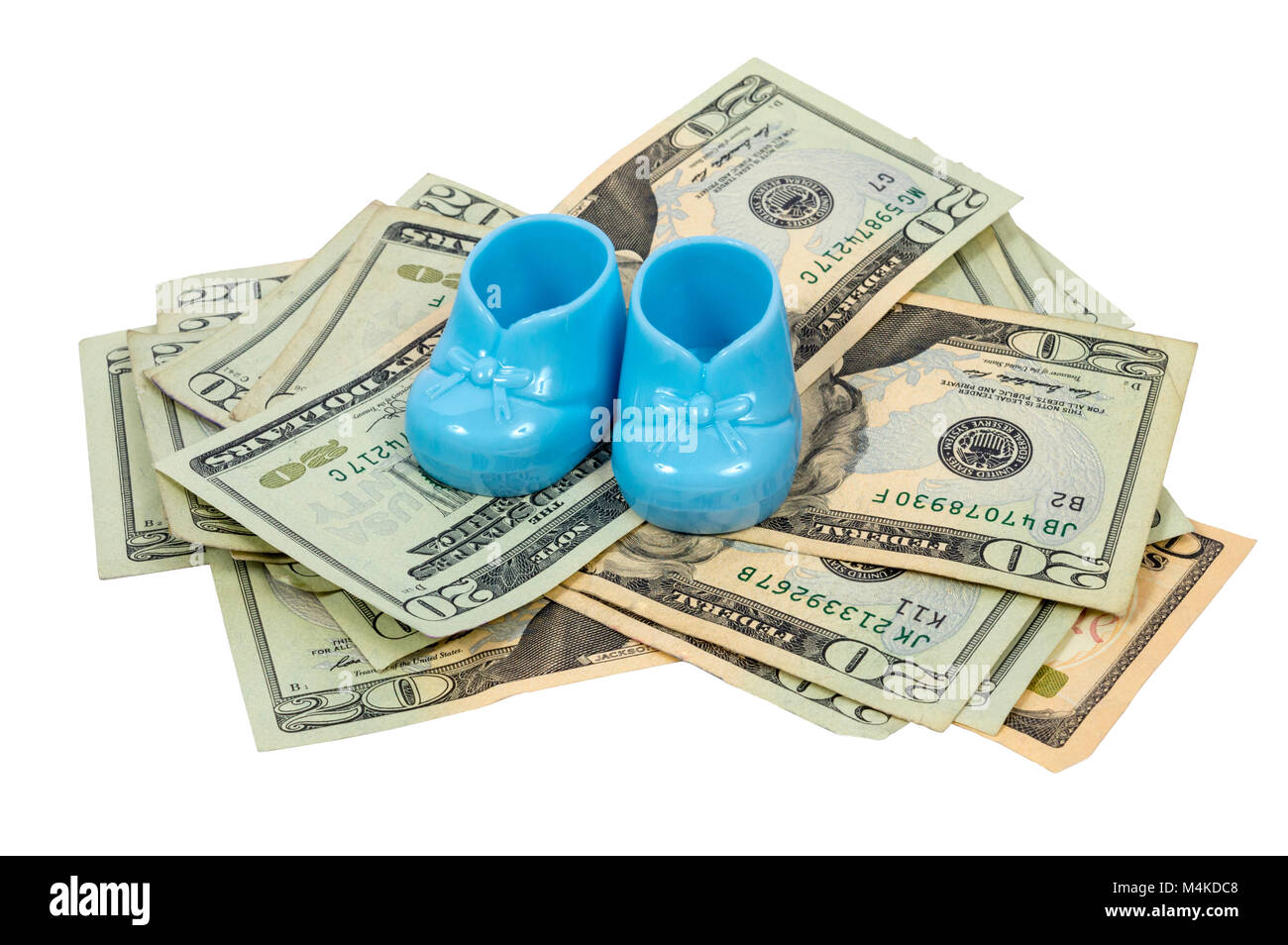 Coup horizontal d'une paire de chaussons pour bébé en plastique bleu reposant sur une pile de vingt projets de dollary. Banque D'Images