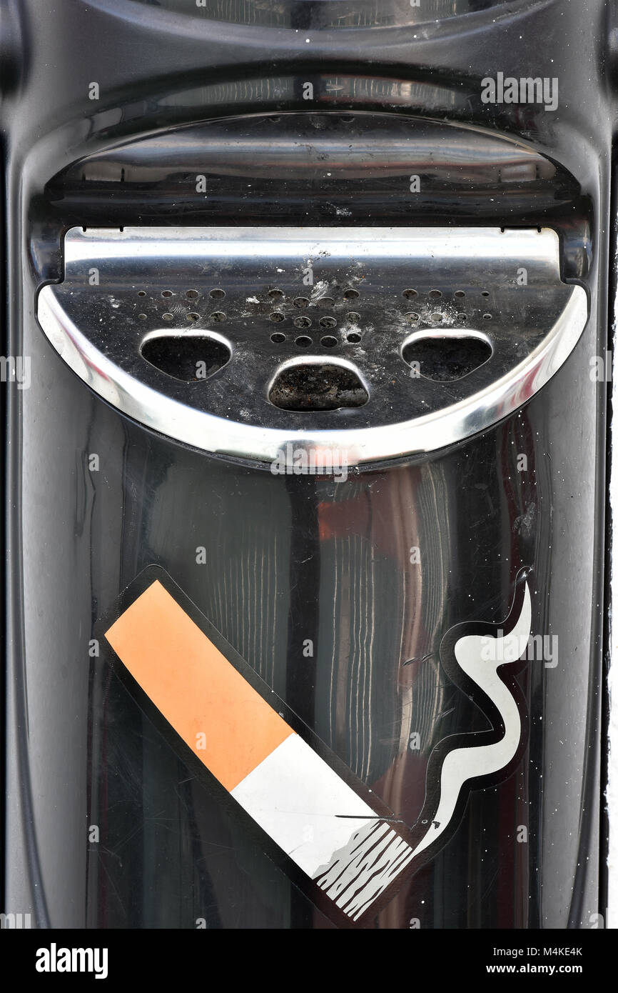 Un brillant chromé fumeurs cendrier ou déraciner bin sur un abri fumeurs à l'extérieur d'un immeuble de bureaux. cendrier vissé sur le mur pour les fumeurs. Banque D'Images