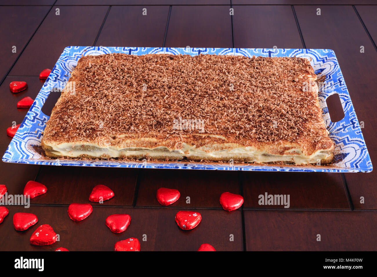 Grand frais et gâteau tiramisu recouvert de copeaux de chocolat. Délicieux tiramisu dessert sur assiette de porcelaine et sur une table en bois. Délicieux chocolat Banque D'Images