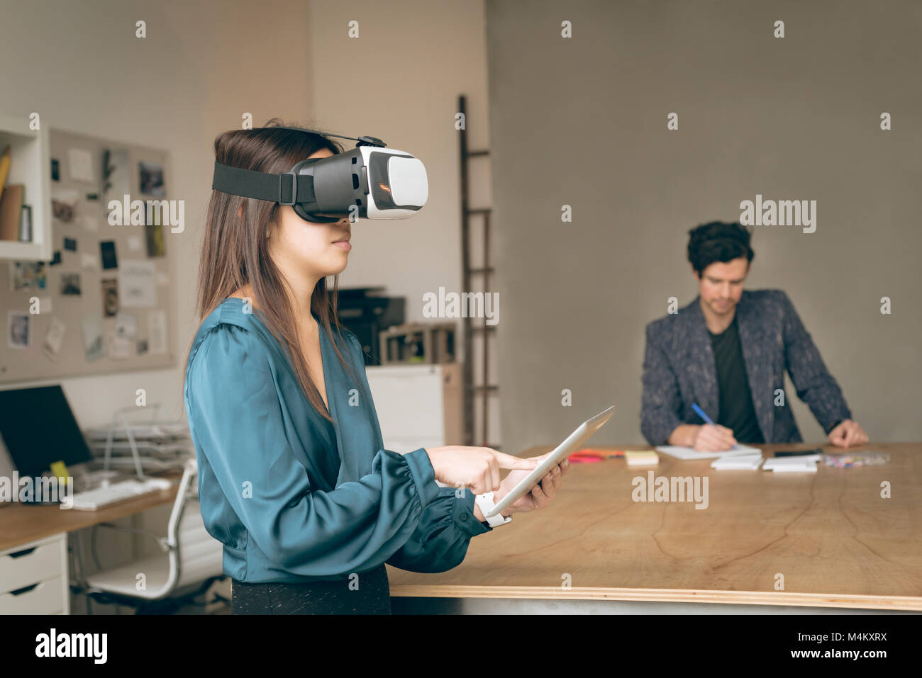 Female executive en utilisant casque de réalité virtuelle et digital tablet Banque D'Images