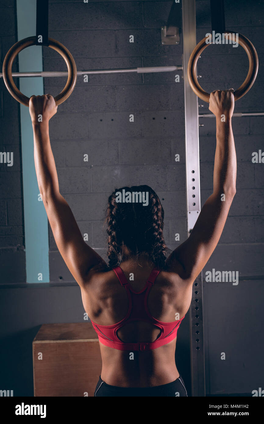 Fit woman exercising with gymnastic rings dans la salle de sport Banque D'Images