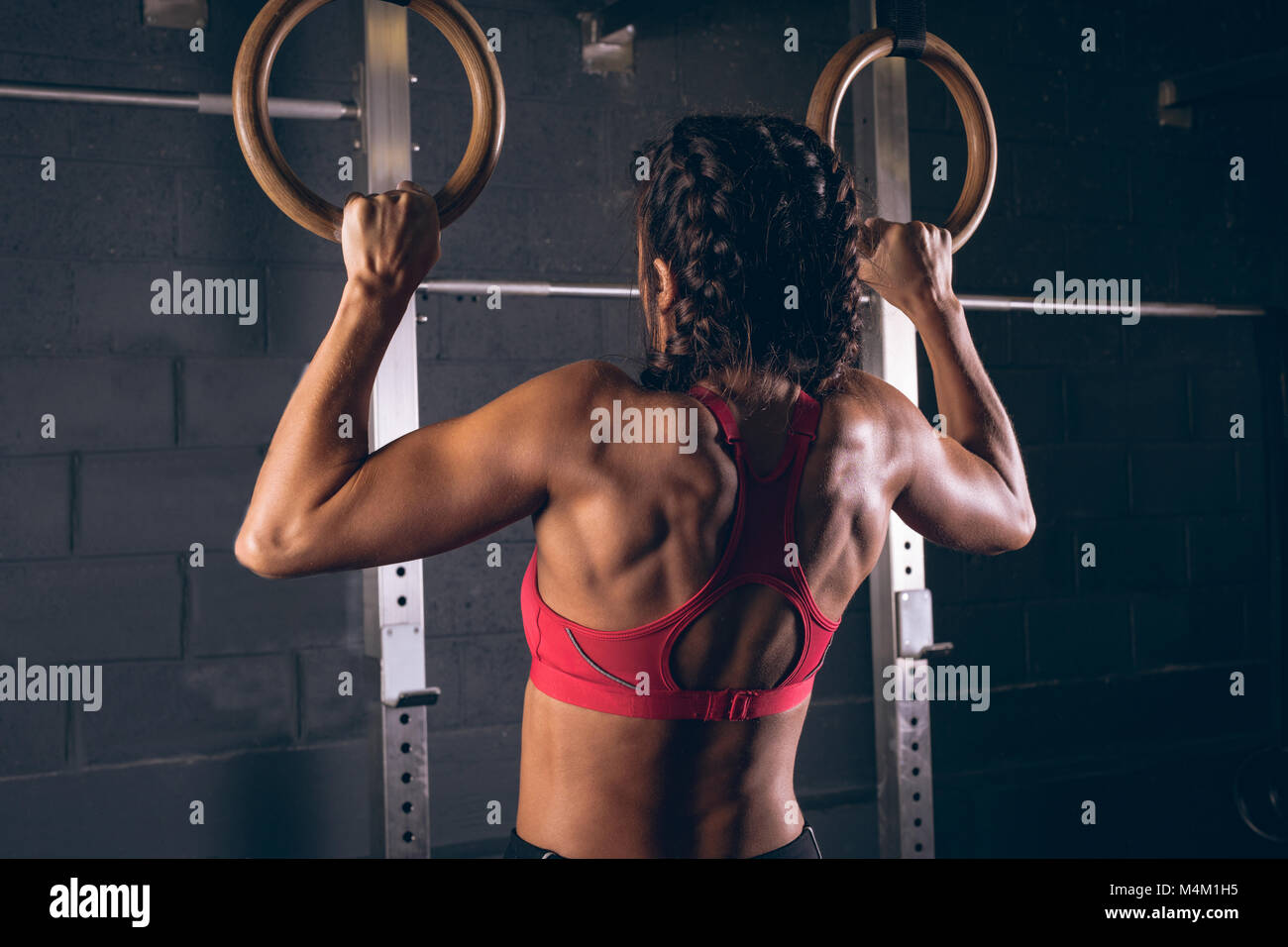 Fit woman en tirant sur les anneaux de gymnastique Banque D'Images