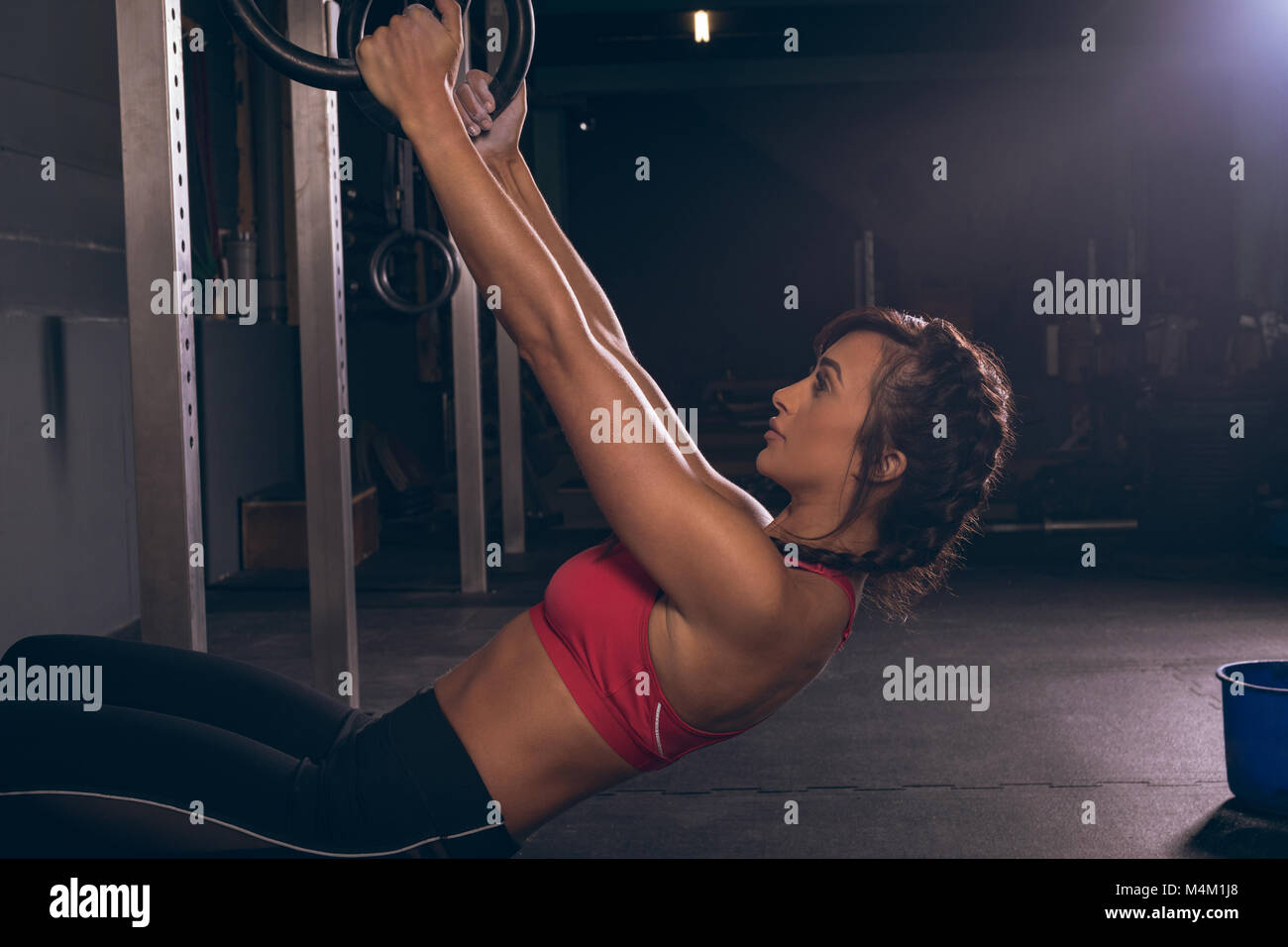 Fit woman en tirant sur les anneaux de gymnastique Banque D'Images
