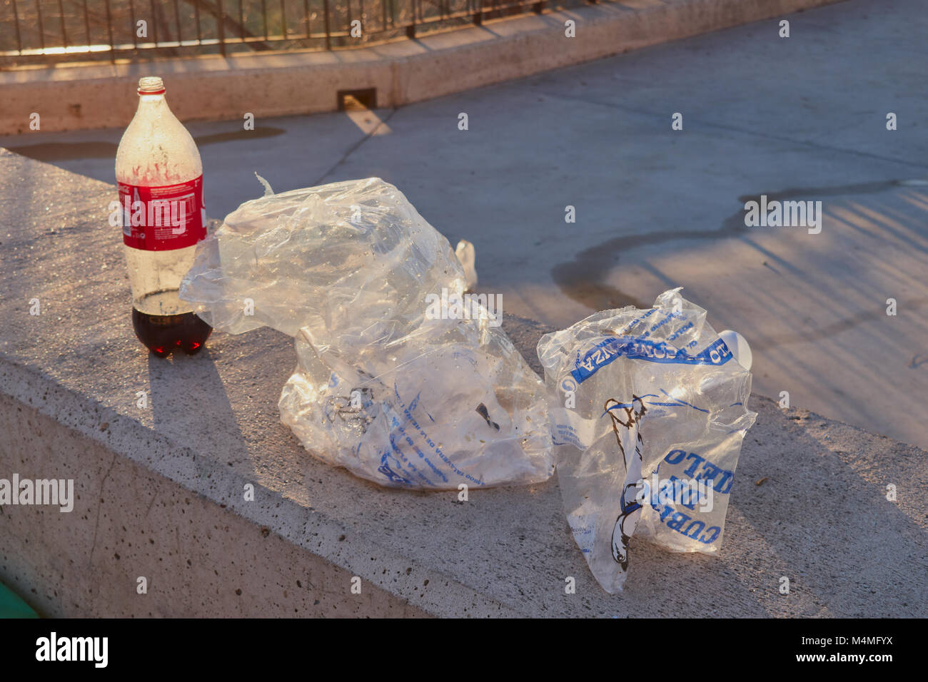 Castilla La Mancha, Toledo, Espagne ; 23 Décembre 2.017 : Reste de bouteille de coca et des ordures des sacs de glace dans un parc Banque D'Images