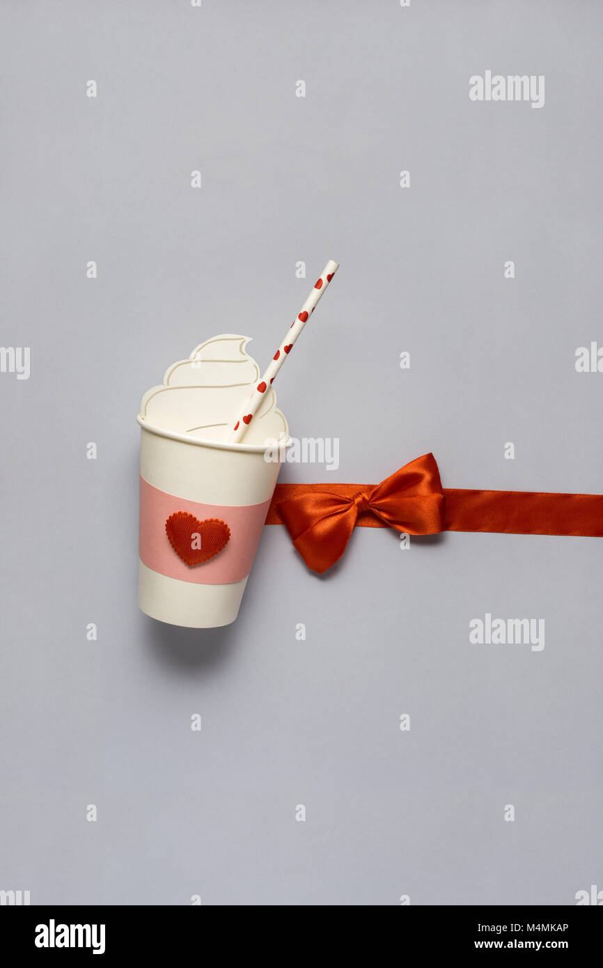 Concept créatif photo de prendre une tasse à café avec des coeurs sur fond gris. Banque D'Images