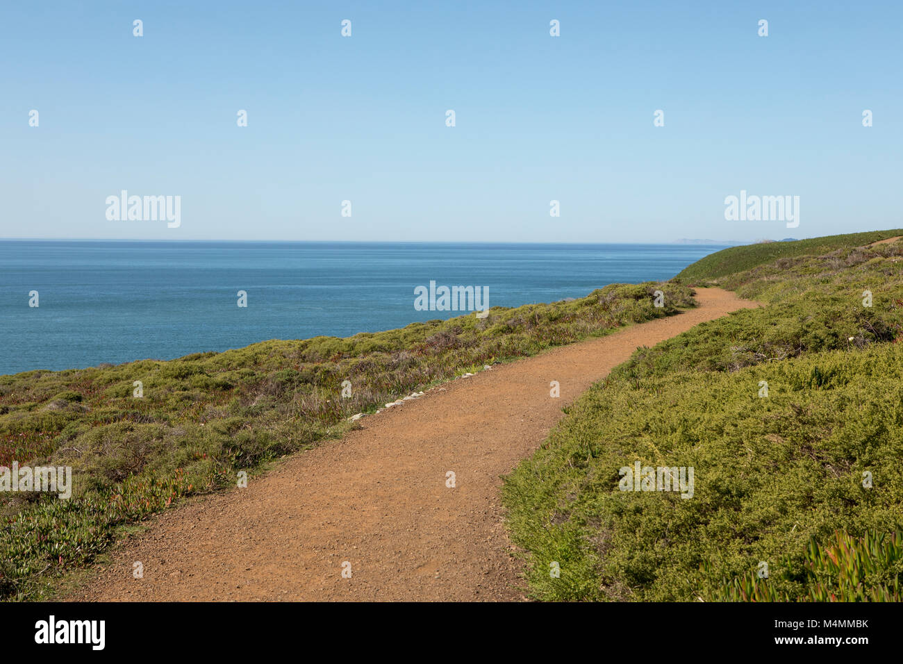 Voie tortueuse le long de la falaise à la pointe Marin, Californie, États-Unis. Ciel bleu clair et une mer calme à la fin de l'hiver. Banque D'Images