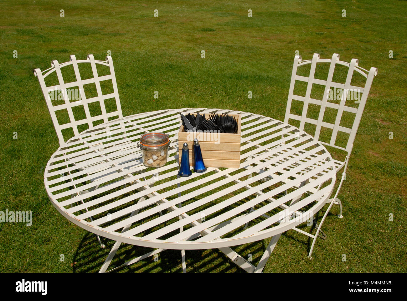 Open air table à manger avec deux chaises, couverts, salière et le sucre Banque D'Images
