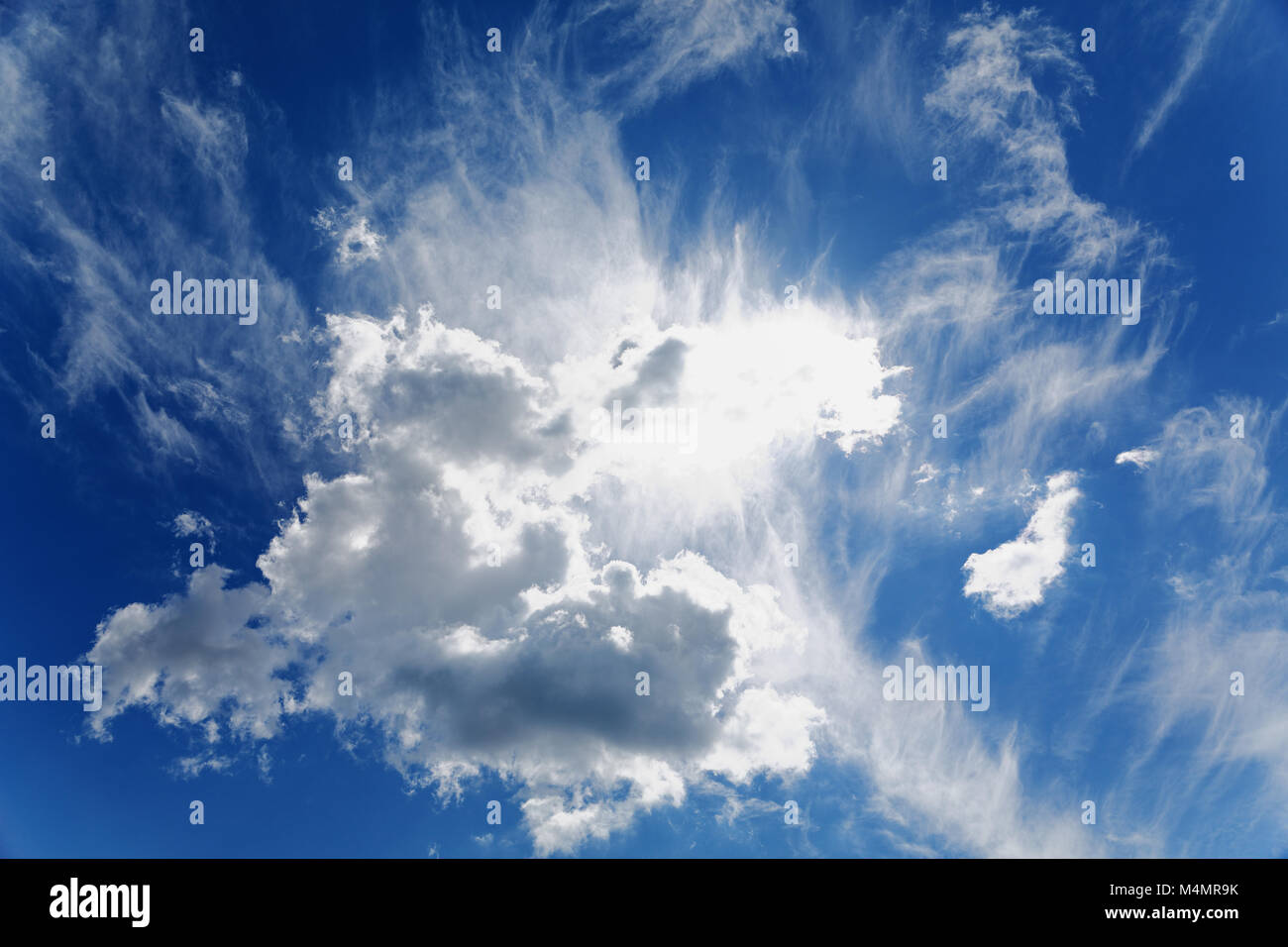 Soleil brille à travers les nuages dans le ciel bleu Banque D'Images