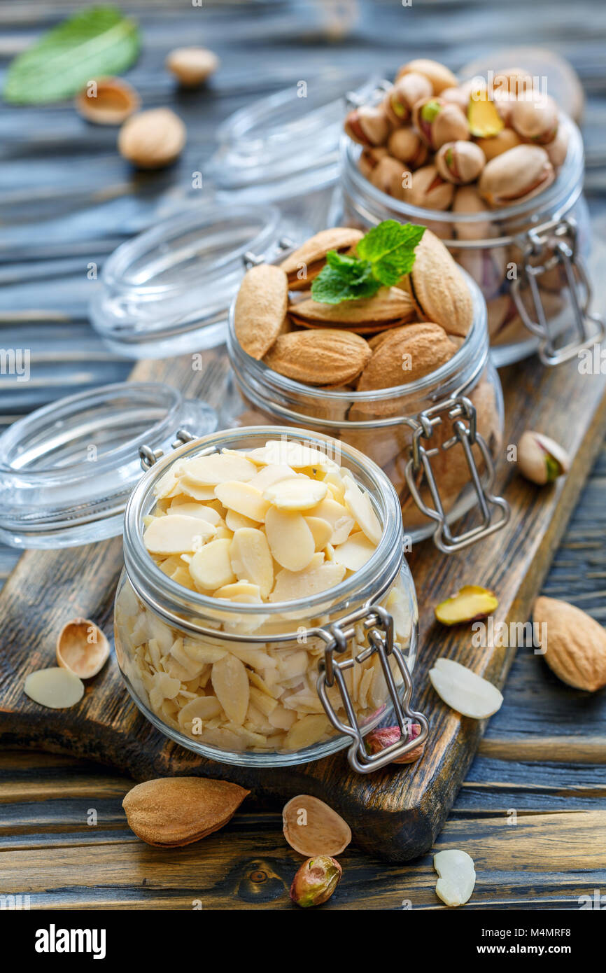 Flocons d'amandes, les amandes et les pistaches en pots. Banque D'Images