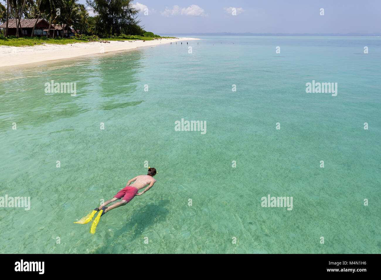 Snorkeler en rouge maillot de natation dans des eaux cristallines de l'eau de mer tropical turquoise sur Paradise Island Banque D'Images