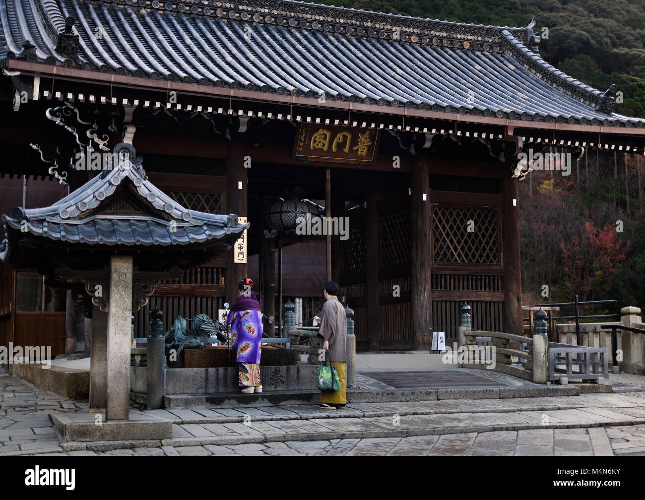 Habillé traditionnellement couple japonais se laver les mains à chozubachi, bassin de nettoyage, à l'entrée de Todoroki-mon gate le Kiyomizu-dera, temple bouddhiste Banque D'Images