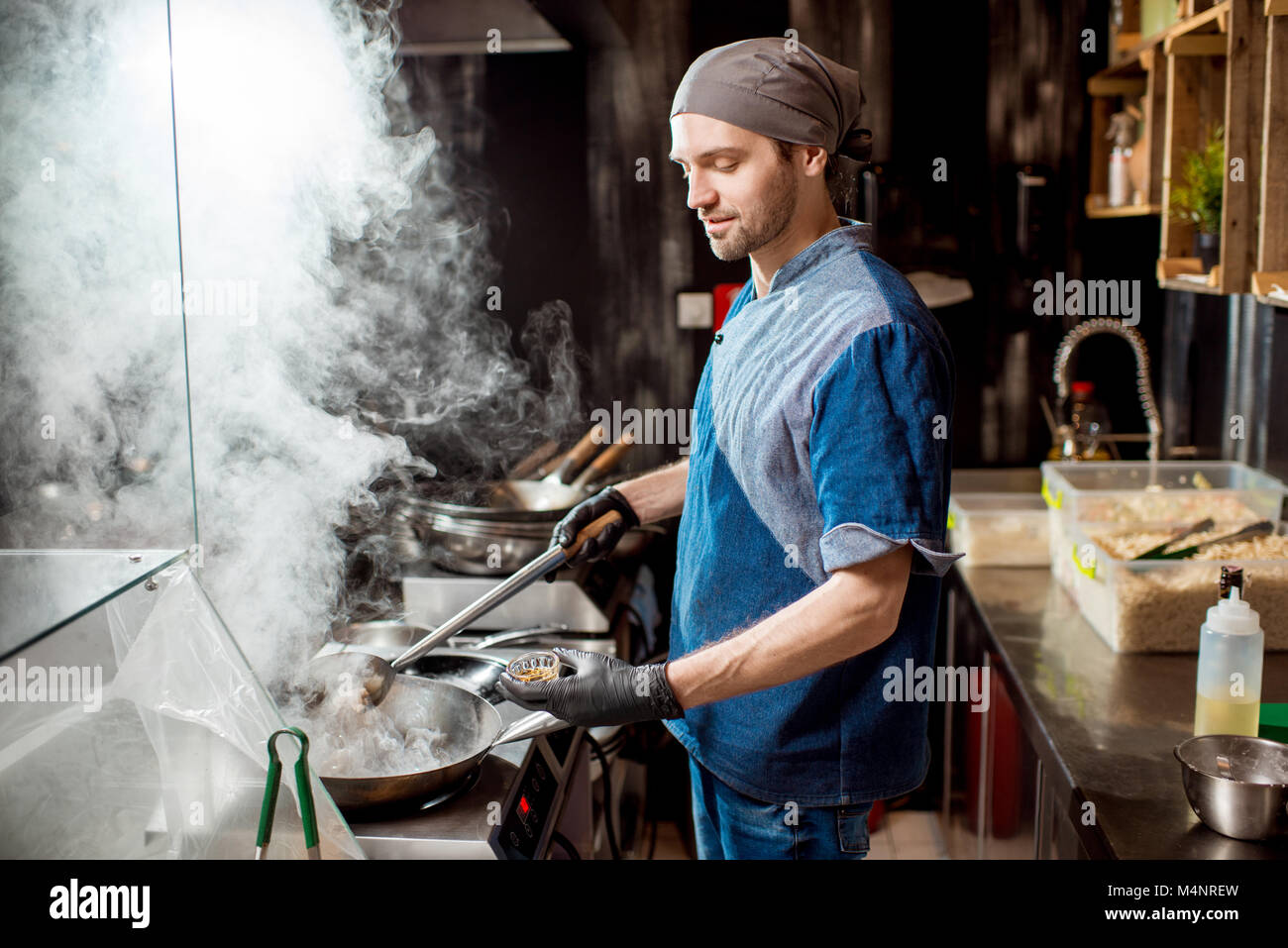 Le cuisinier en chef de cuisine dans la cuisine asiatique Banque D'Images