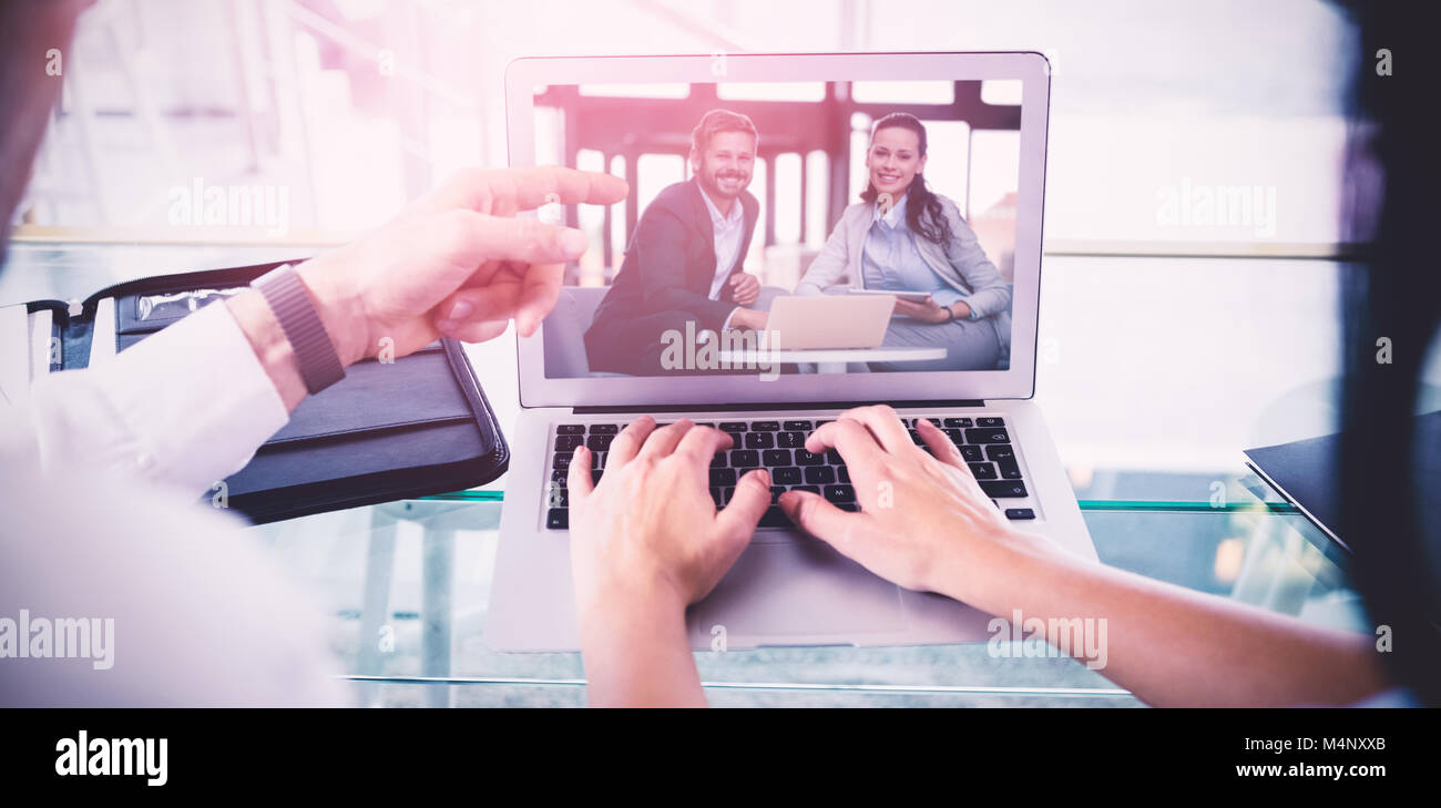 Image composite de business colleagues discussing over laptop Banque D'Images