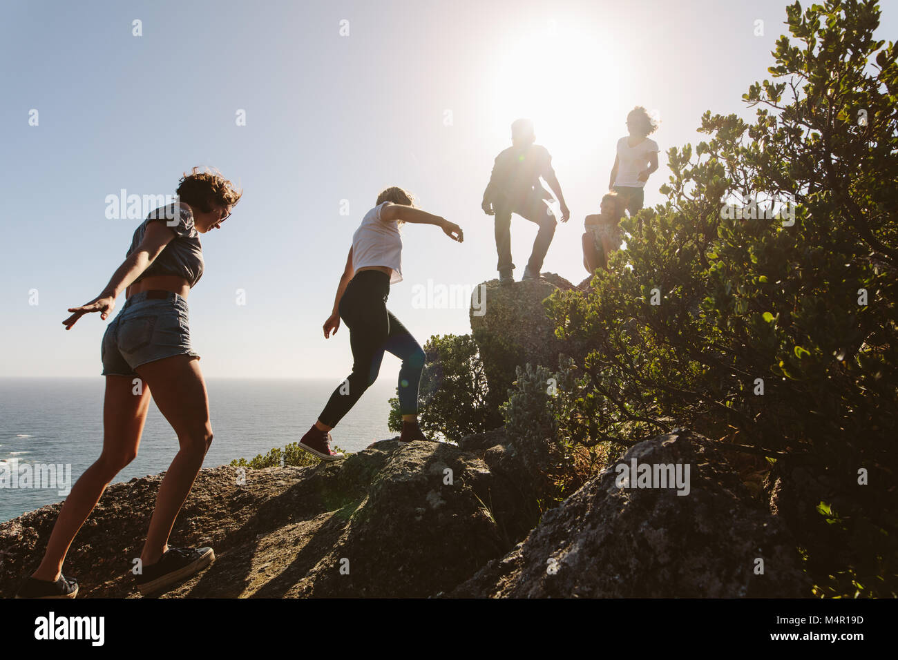 Groupe d'amis sur une montagne. Les jeunes en montagne randonnée sur une journée d'été. Les hommes et les femmes des rochers d'escalade. Banque D'Images
