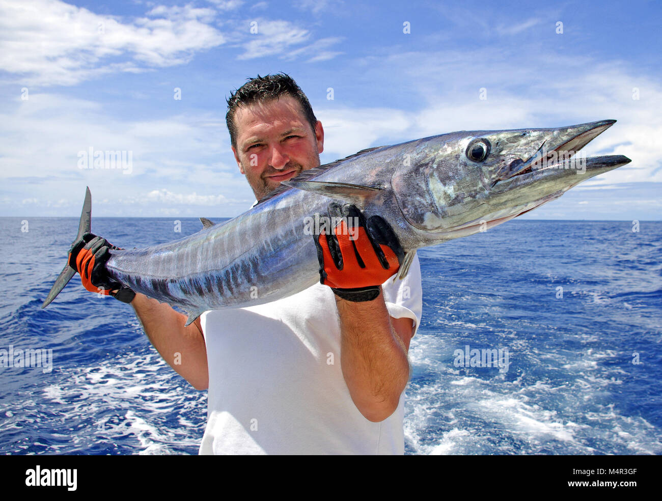 La pêche en haute mer, pêche au gros. prise de poissons. Lucky fisherman holding un énorme poisson wahoo Banque D'Images