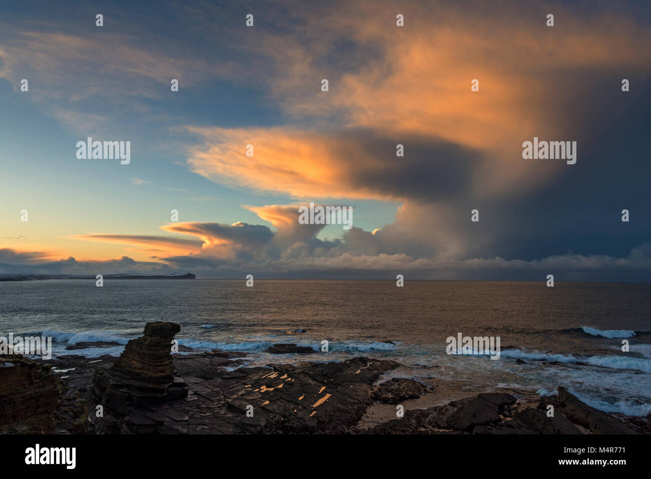 Cumulonimbus nuage au coucher du soleil sur Dunnet Head et le Pentland Firth, de la pile de la mer Men of Mey, St. John's point, Caithness, Écosse, Royaume-Uni Banque D'Images
