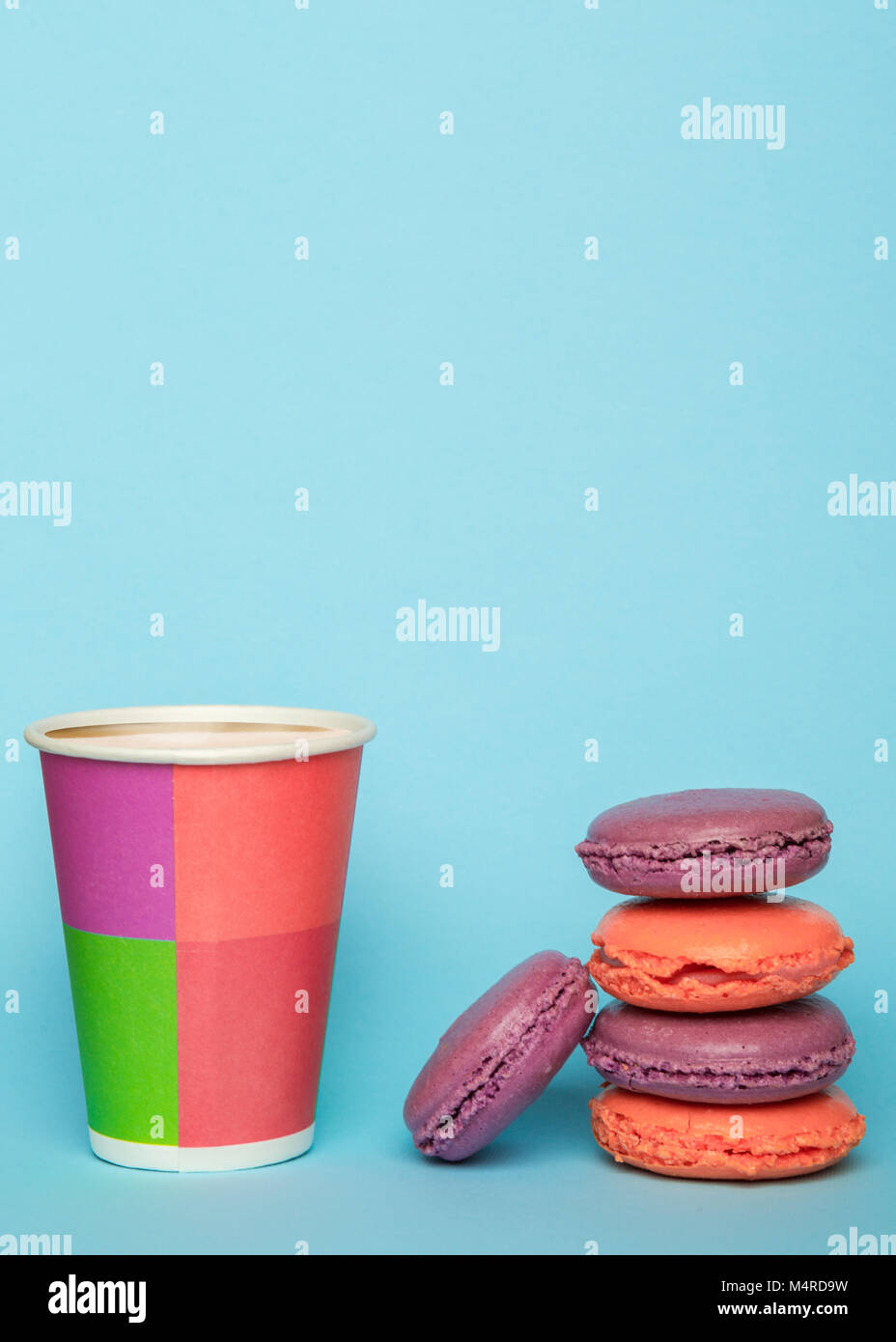 Macarons français et tasse de papier avec latte sur le fond de couleur bleu pastel. Avec petit-déjeuner. macaron facile Banque D'Images