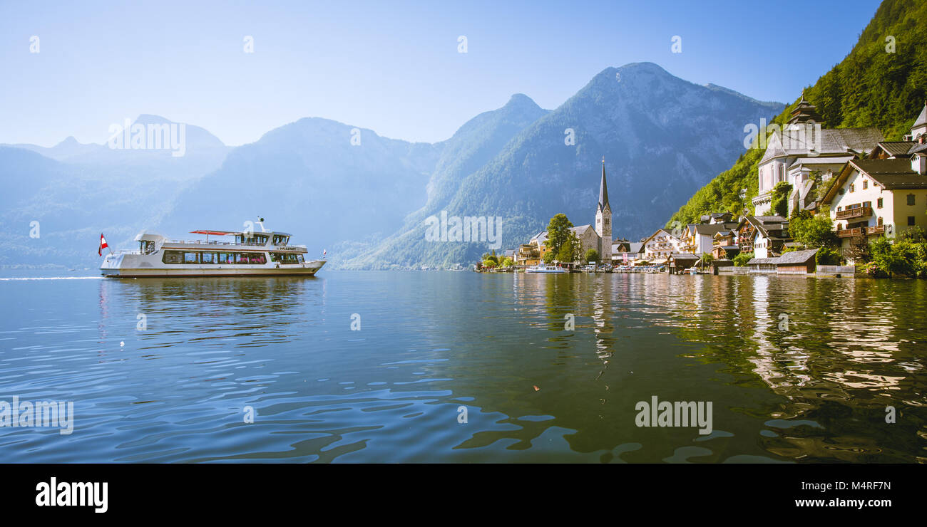 Vue panoramique du célèbre village au bord du lac de Hallstatt dans les Alpes autrichiennes avec navire à passagers traditionnels sur une belle journée ensoleillée en été, Autriche Banque D'Images