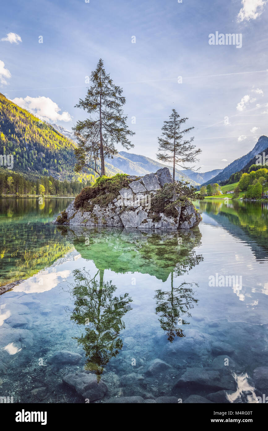 Belle scène d'arbres sur une île de roche dans un paysage idyllique au charmant lac Hintersee avec ciel bleu et nuages dans l'été, parc national de Berchtesgaden Banque D'Images