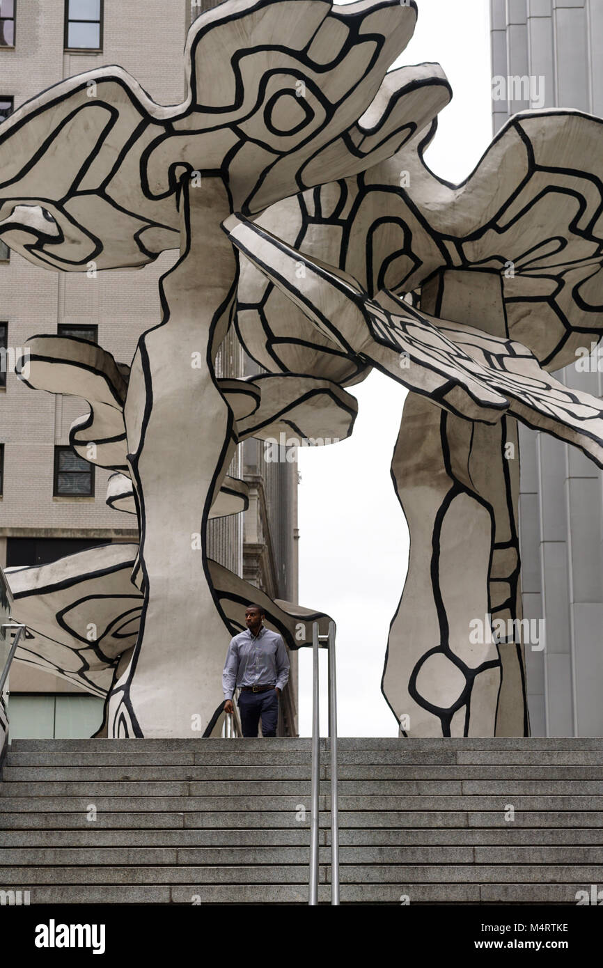 Un homme qui passe sous une installation d'art public dans la ville de New York. Banque D'Images