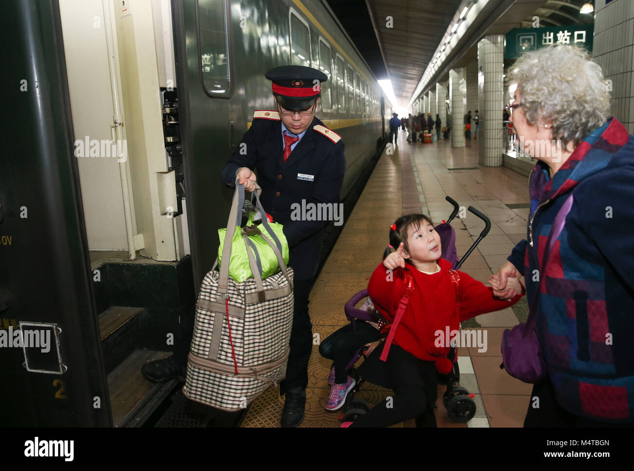 Shanghai. Feb 18, 2018. Un accompagnateur de la Z99 un passager permet de transporter des bagages sur le 18 février 2018. Le 42-year-old Kan Xiaojun est un chef d'orchestre de la Z99. Il a été de service pendant la Fête du Printemps les rush, également connu comme le Chunyun, depuis 12 ans et a raté une réunion de famille du festival pour sept fois. La plupart des membres de l'équipe de Kan viennent de Chine, région du delta du fleuve Yangtze. Parmi eux, le plus jeune accompagnateur est 20. Credit : Ding Ting/Xinhua/Alamy Live News Banque D'Images