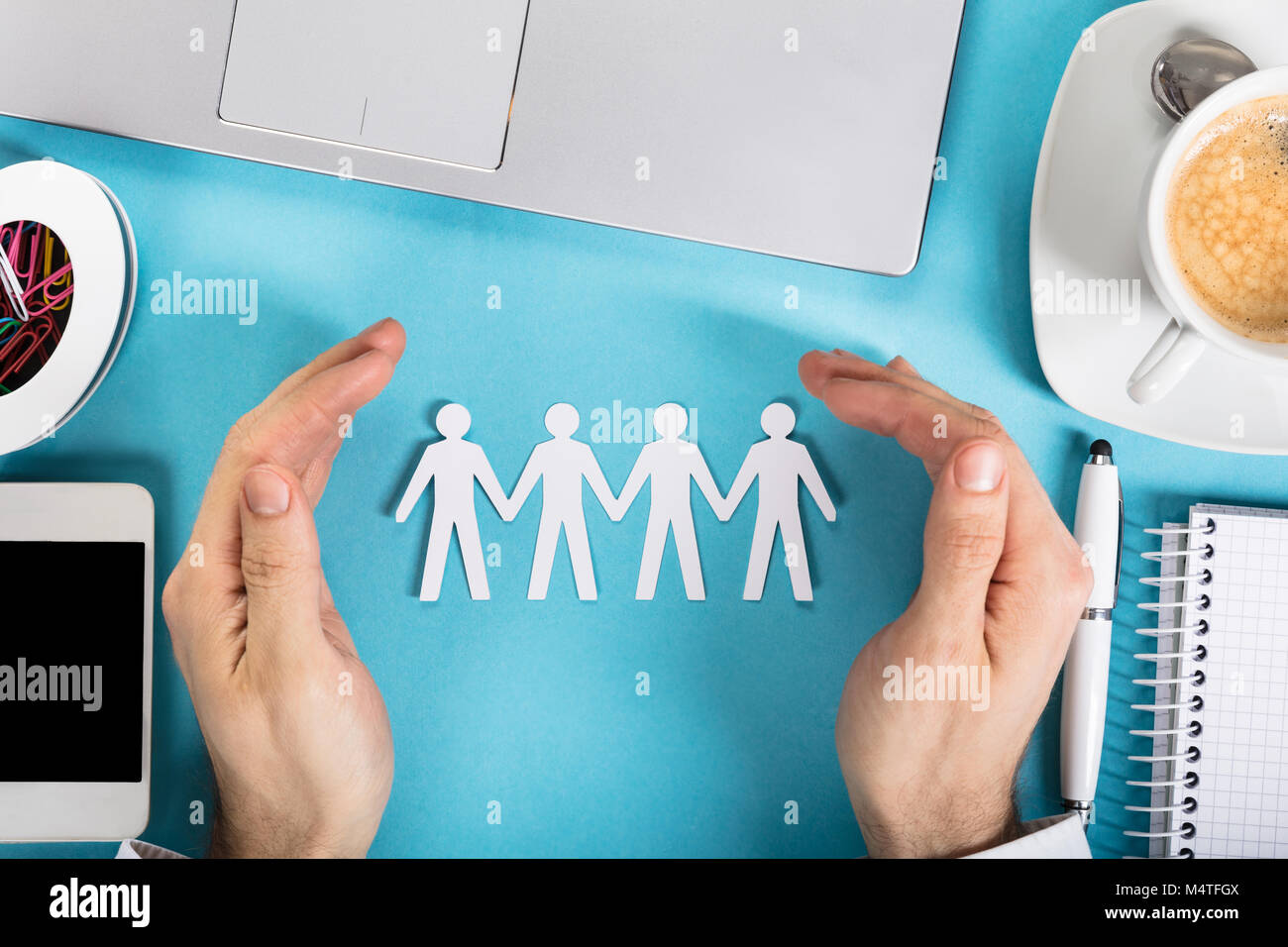 L'homme d'une part protéger le papier découpé Figure humaine sur Office 24 Banque D'Images