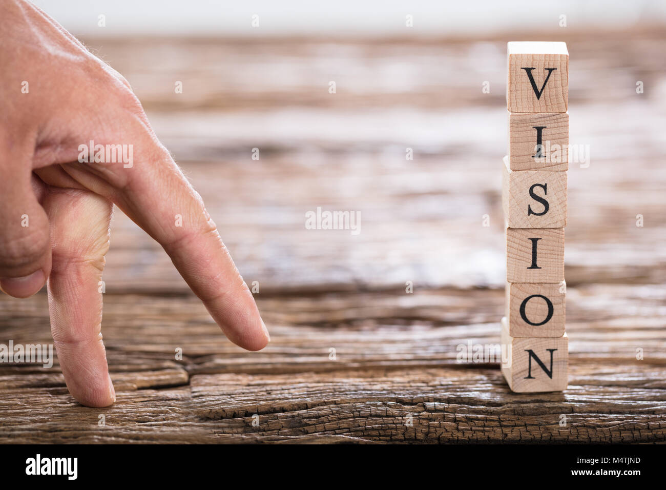 Close-up of a person's Finger et Vision mot empilé sur un bloc en bois Banque D'Images