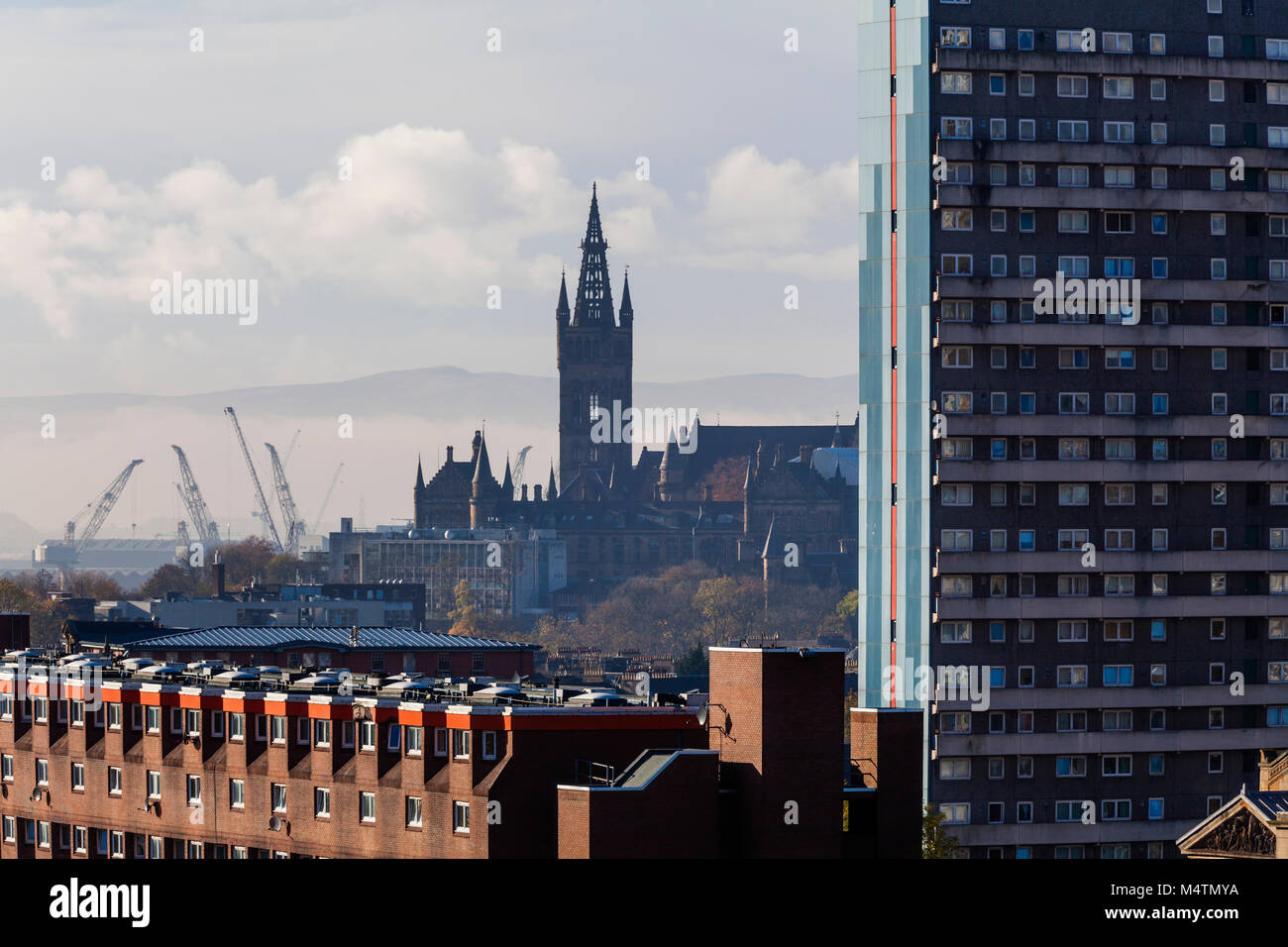 Vue sur les gratte-ciel de Glasgow avec vue sur les logements sociaux vers le clocher de l'Université de Glasgow avec grues de chantier en arrière-plan, Écosse, Royaume-Uni Banque D'Images
