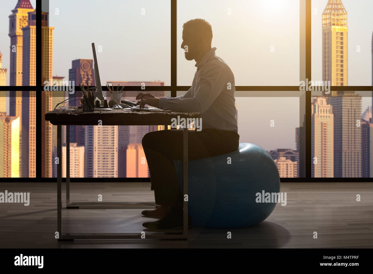 Close-up of Woman Sitting on Fitness Ball bleu travaillant dans un bureau moderne Banque D'Images