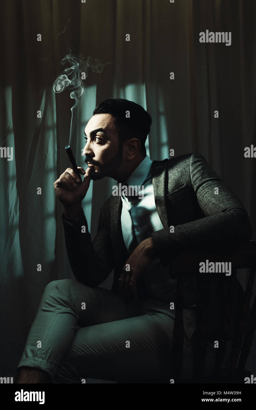 Image style film noir avec ton cinématographique de l'homme fumant un cigare Banque D'Images